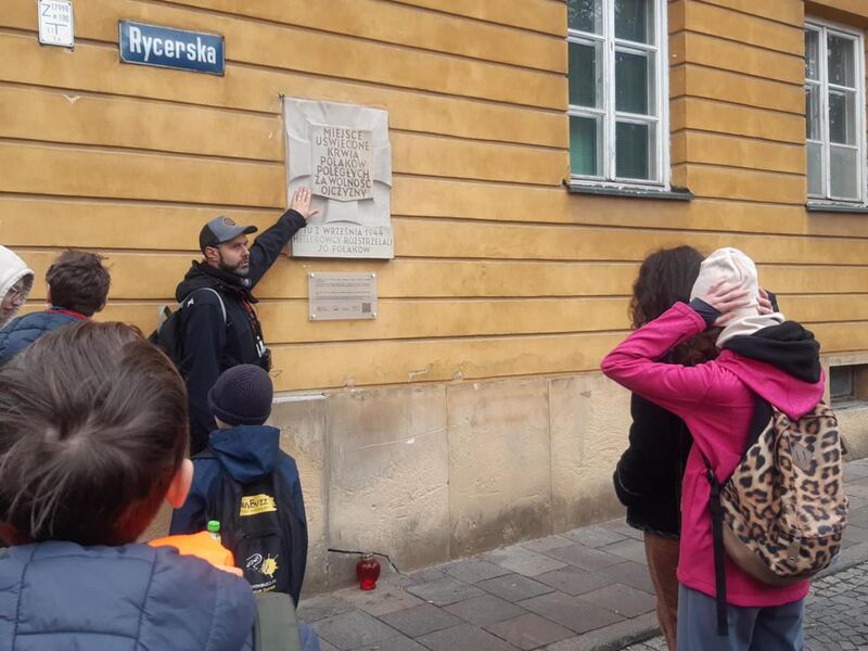 Grupa przy tablicy pamiątkowej na ulicy Rycerskiej